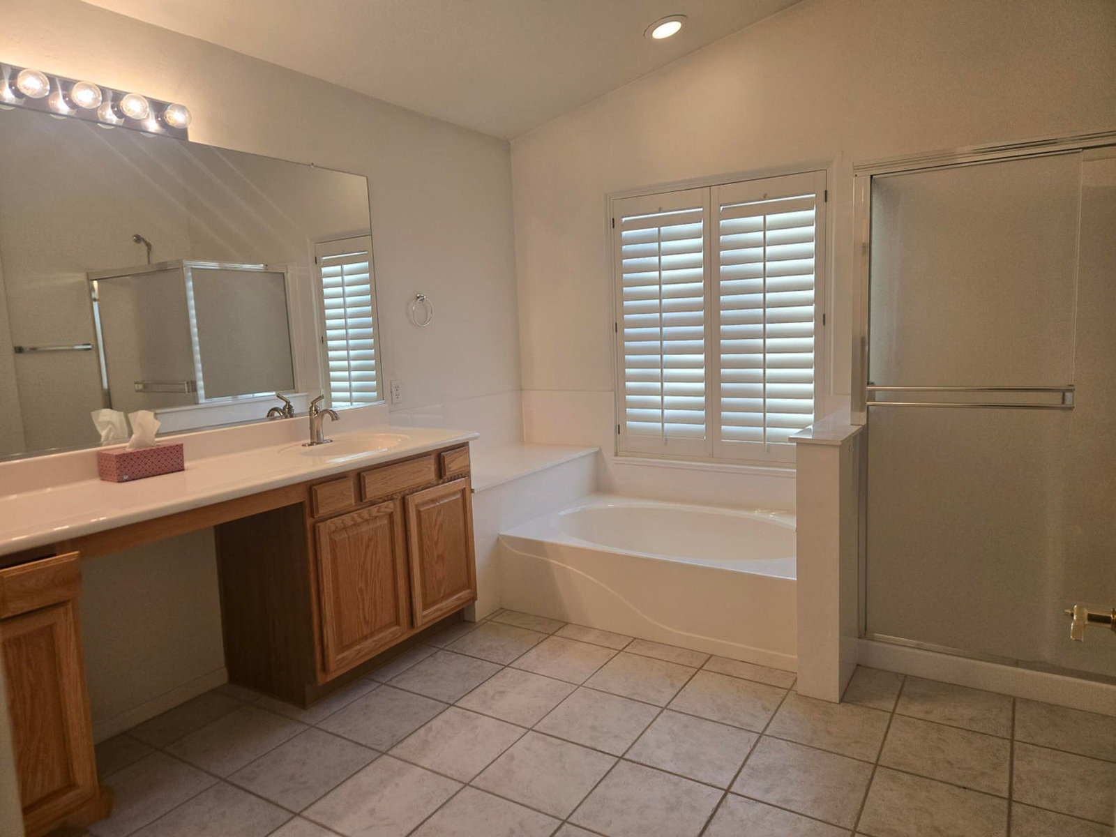 Bathroom with large vanity, built-in tub, and walk-in shower