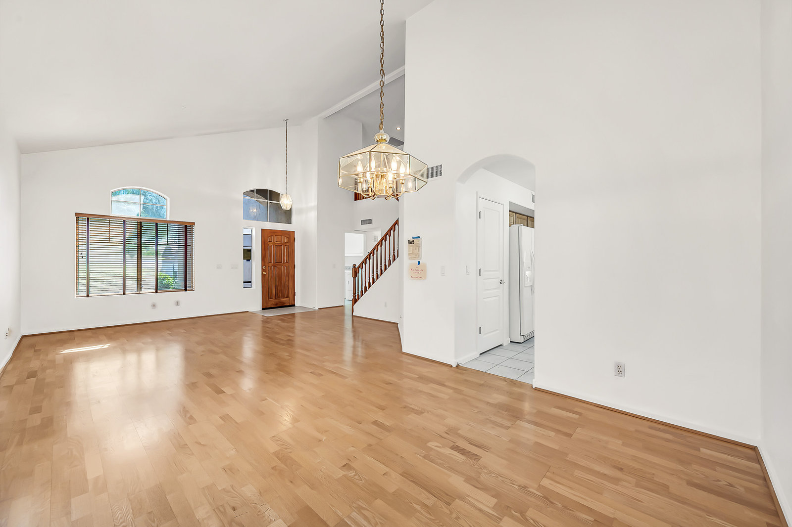 Empty living room with hardwood floor and high ceiling