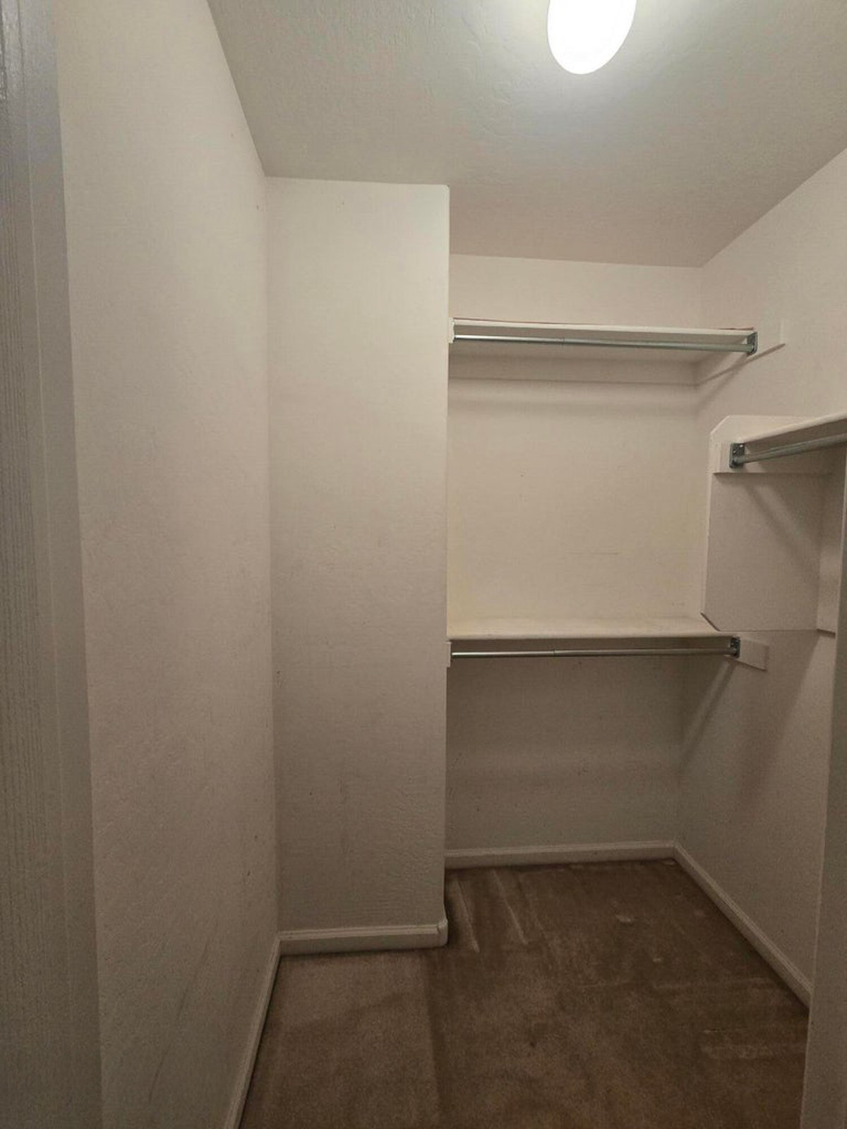 Empty walk-in closet with shelves