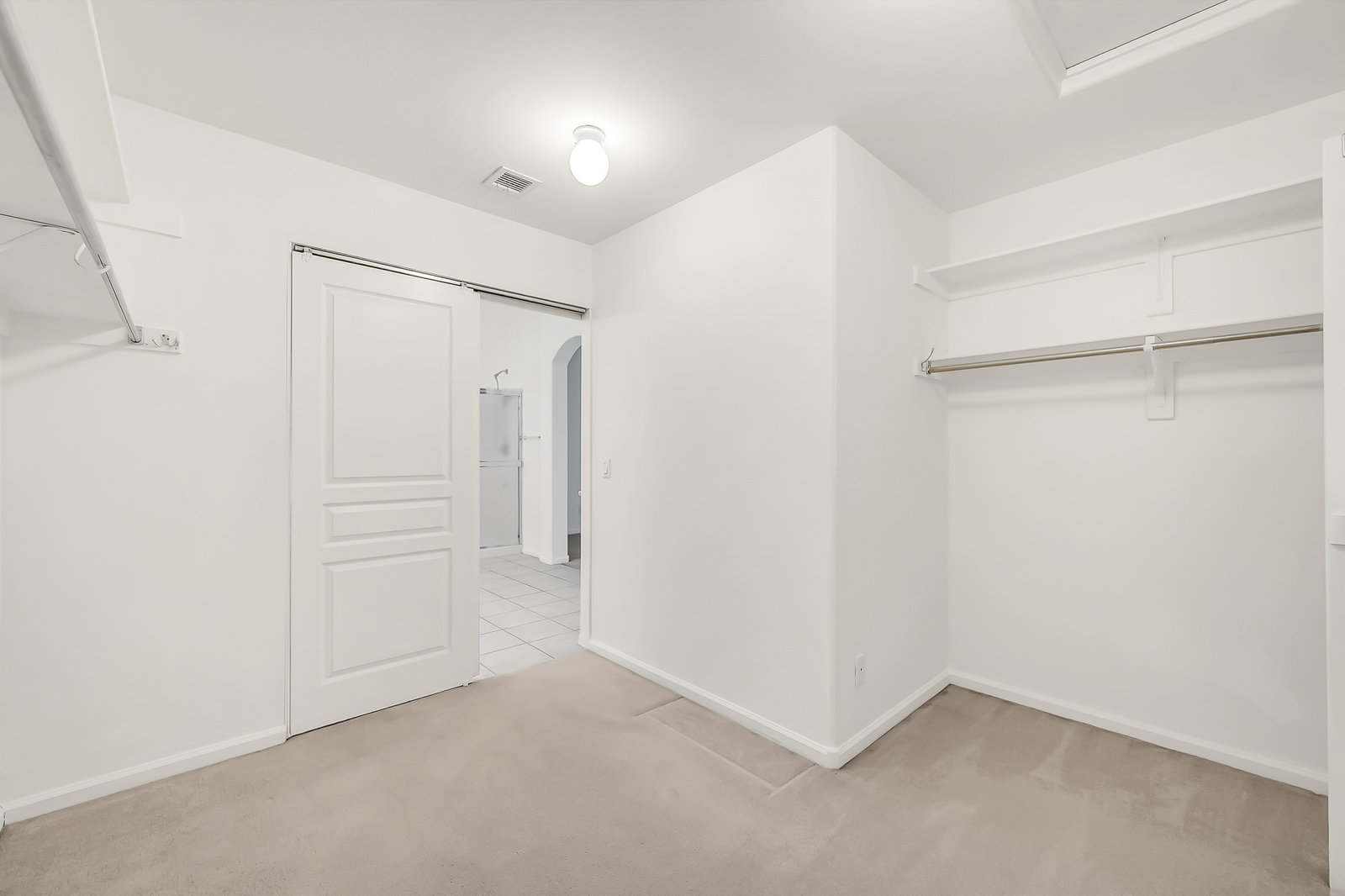 Neutral room with sliding barn door and open closet