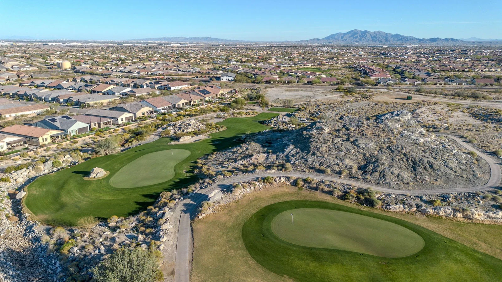 Aerial view of a Verrado golf course with homes and the White Tank Mountains, Buckeye, AZ