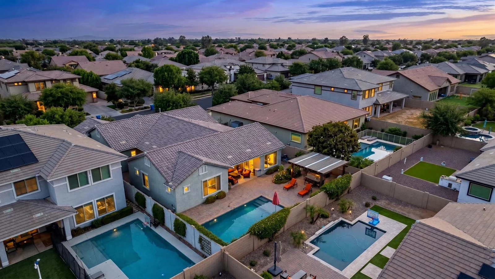 Aerial of Gilbert homes and pools at twilight
