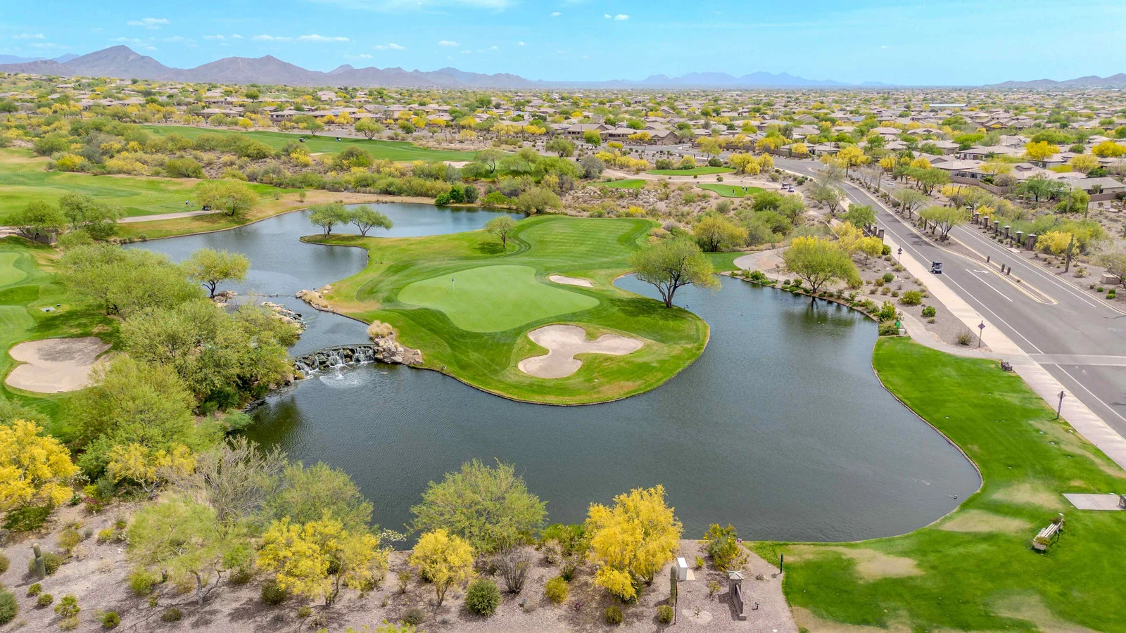 Drone photography of a golf course with a lake and residential area