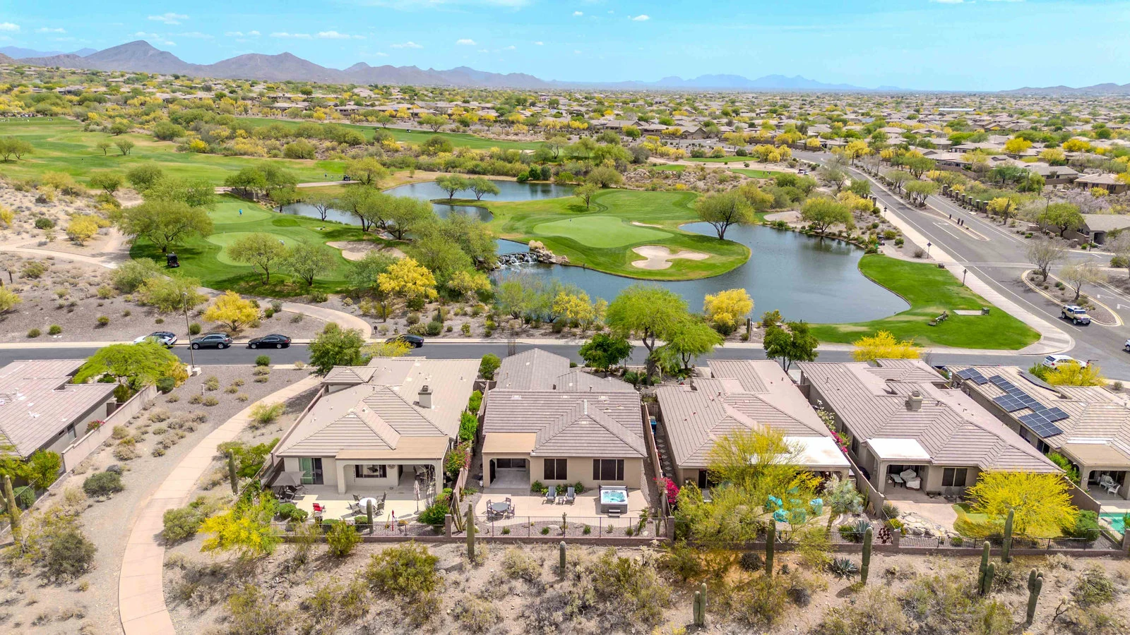 Drone view of houses and golf course with lake