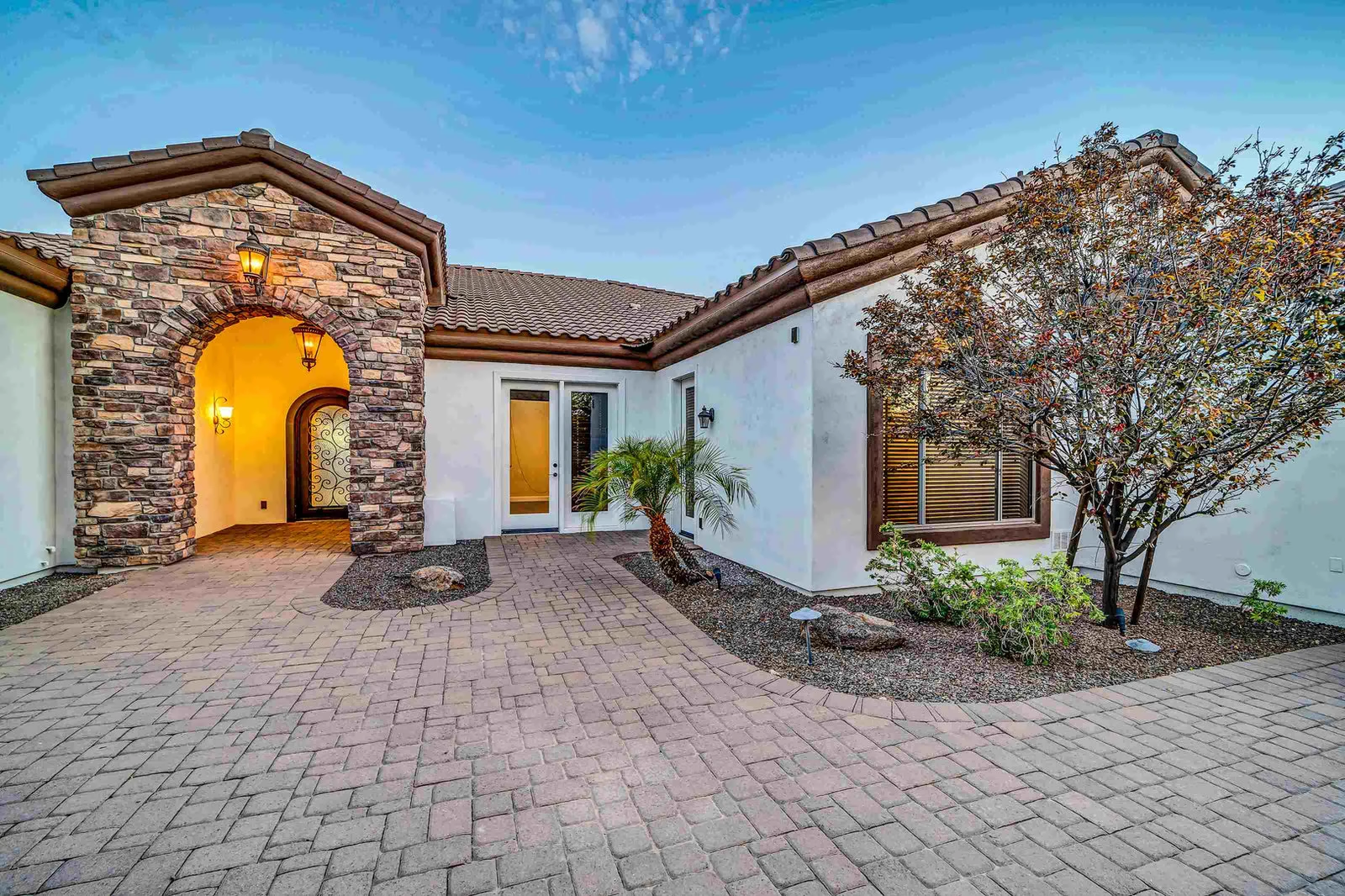 Exterior of house with stone archway and paved entrance