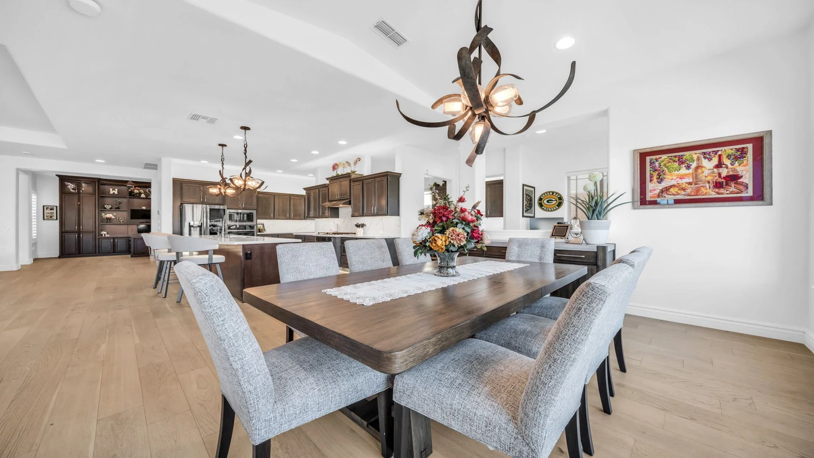 Modern dining room with wood table, gray chairs, open kitchen