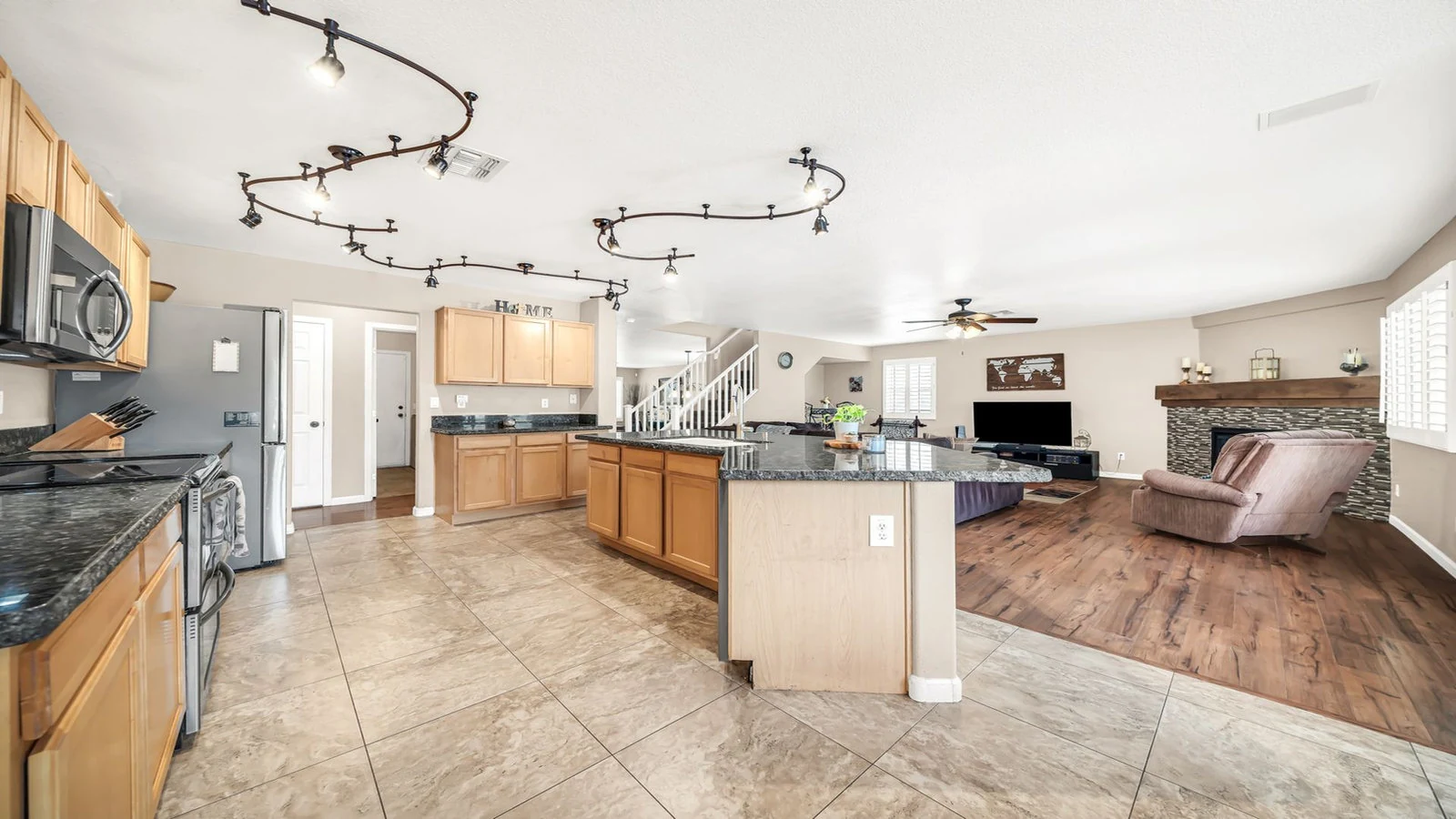 Modern kitchen island opens to living room fireplace real estate photography Glendale AZ | The Listing Bees