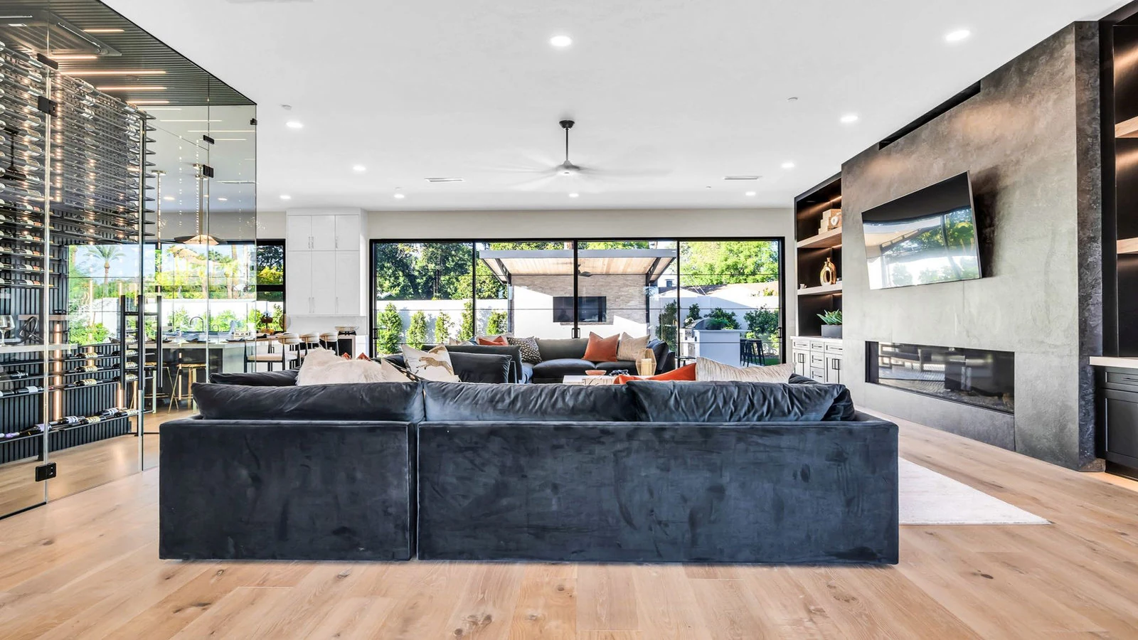 Modern living room with dark sectional, fireplace, and wine storage