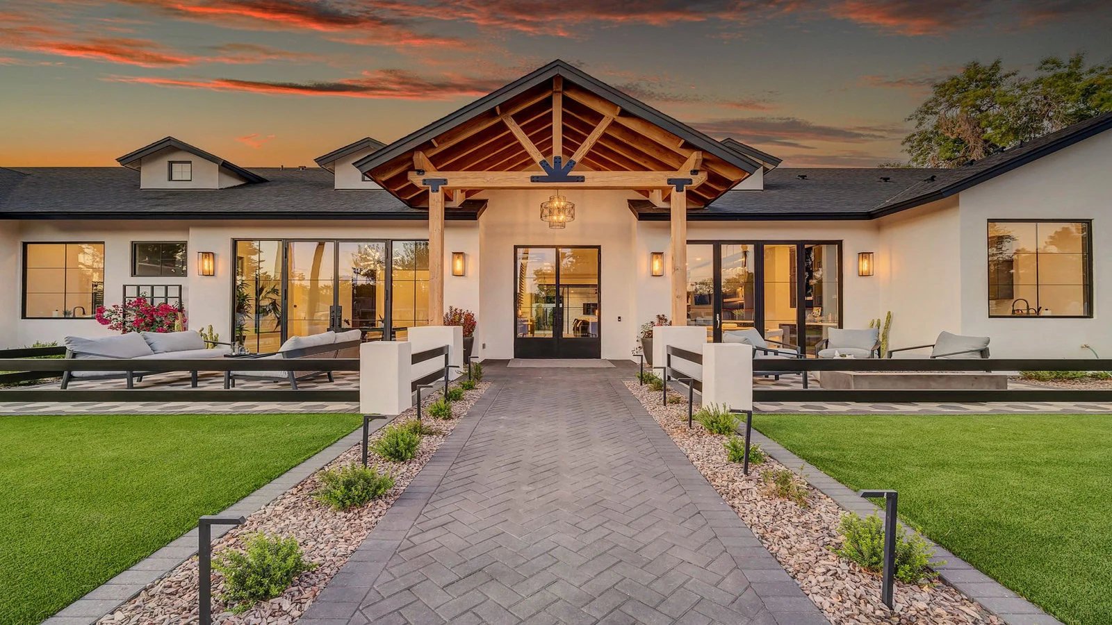 Modern white house exterior with paved path at sunset