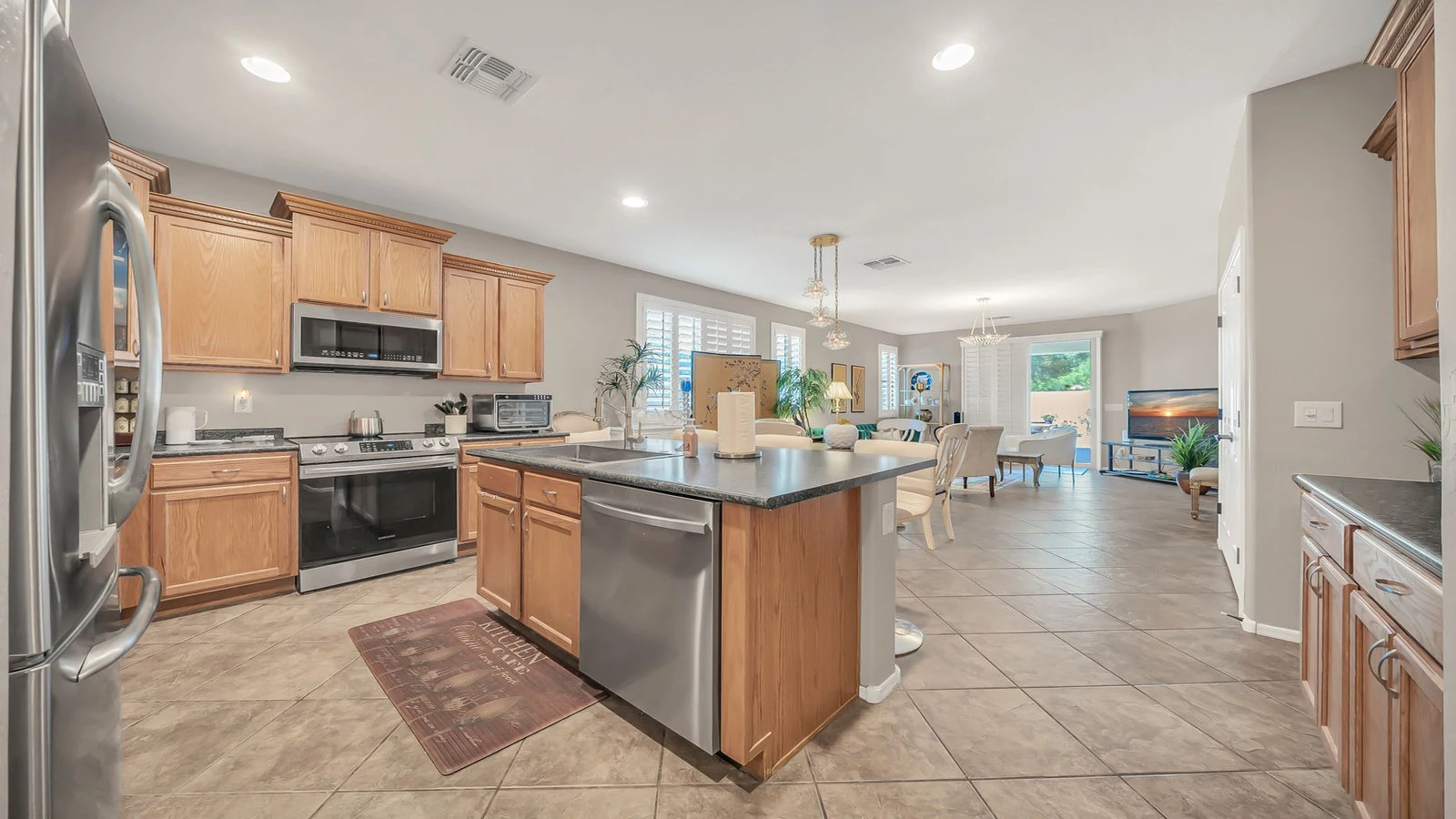 Open concept kitchen wood cabinets island living room real estate photography Surprise AZ | The Listing Bees