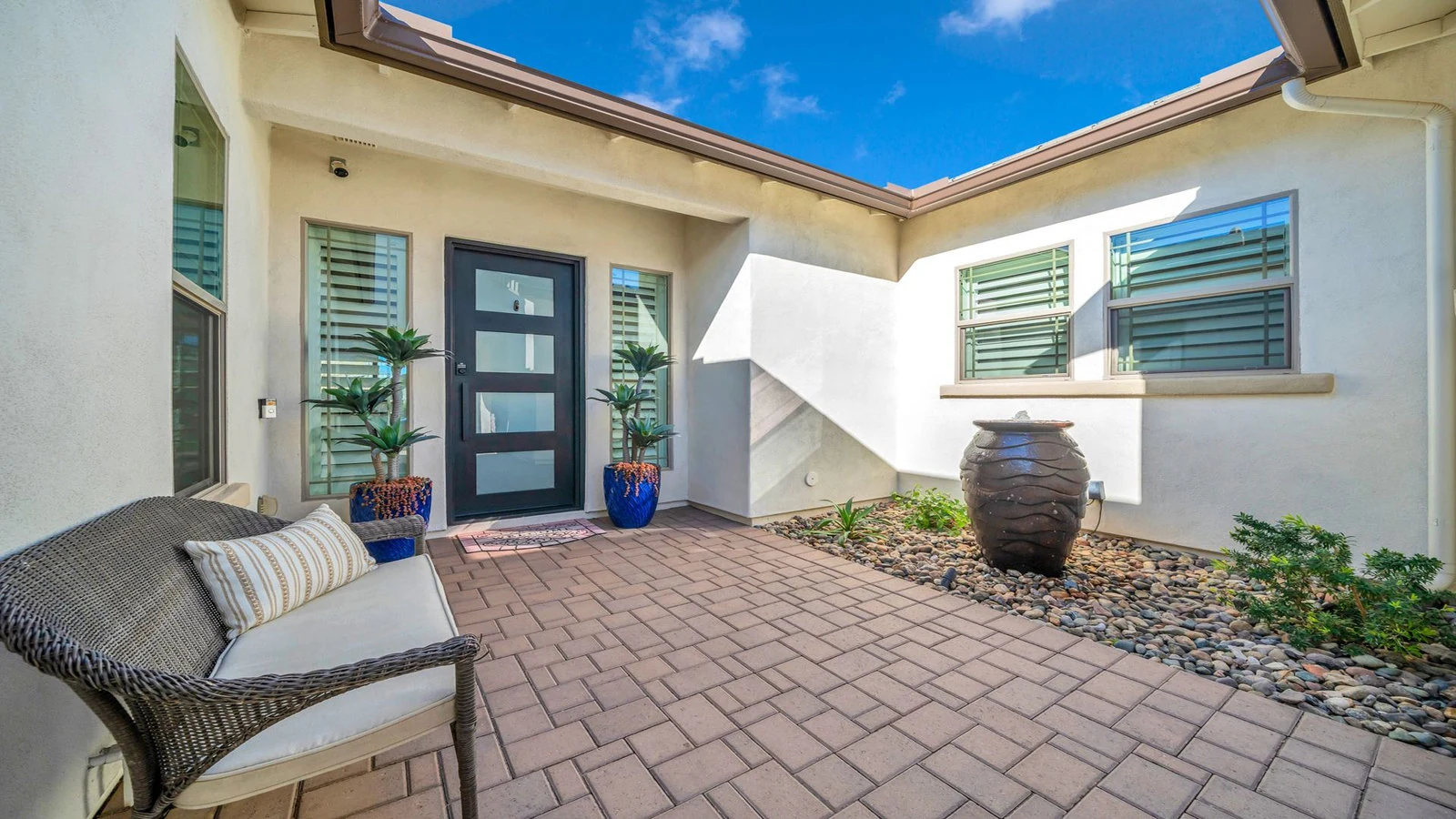 Paved entryway to a house with a bench
