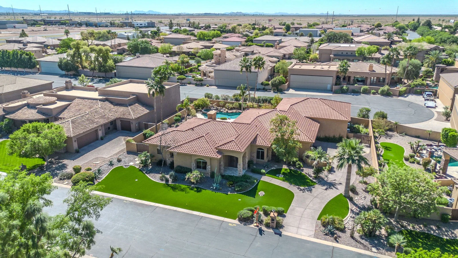 Aerial view of an Ocotillo waterfront home with a lake behind it in Chandler, AZ