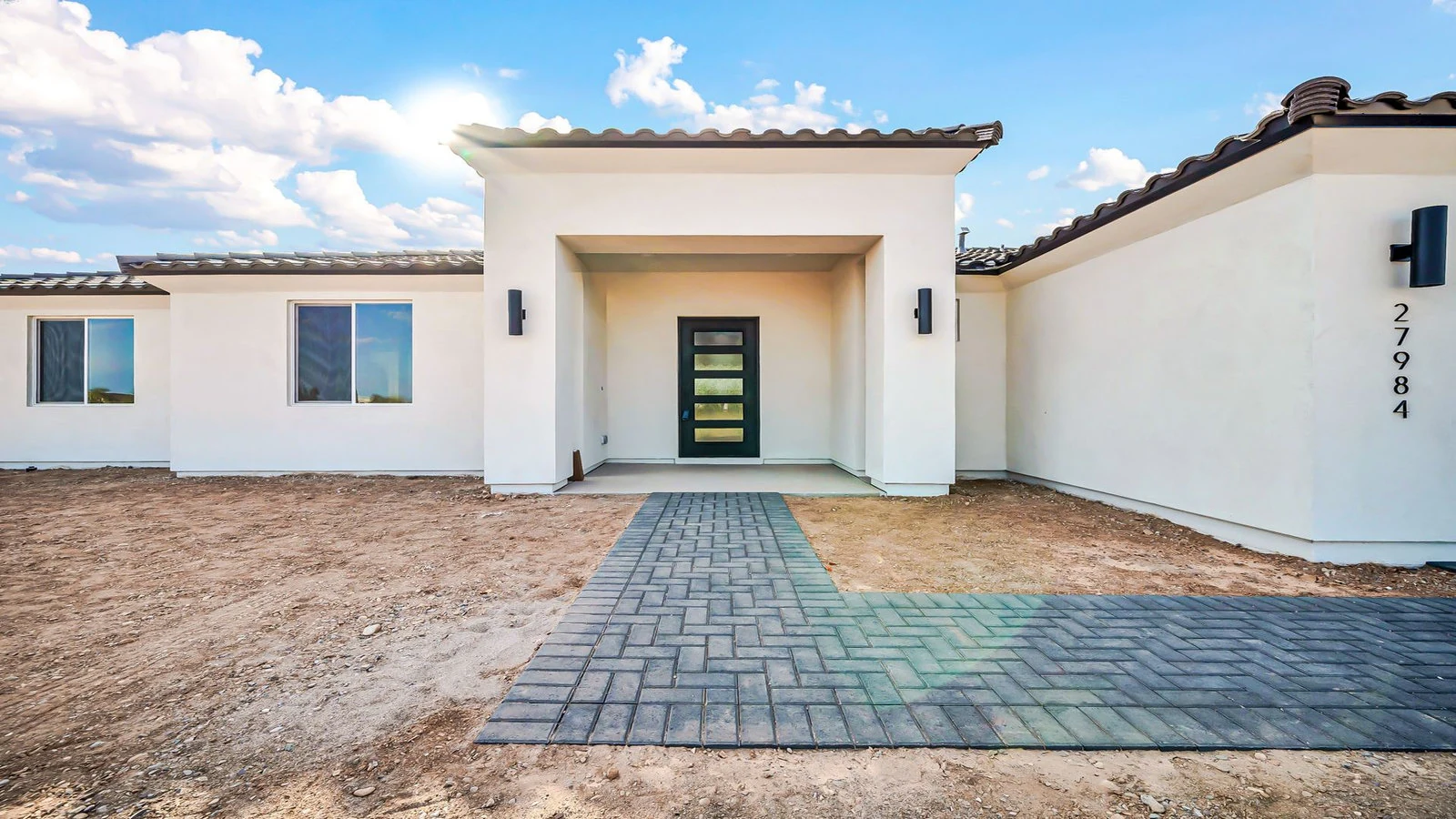Modern white home dark door paved walkway real estate photography Surprise AZ | The Listing Bees