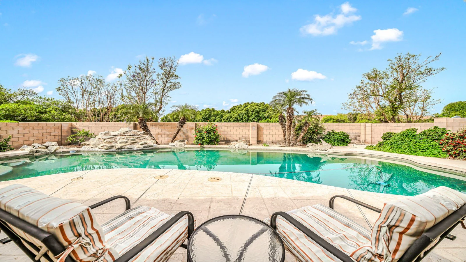 Swimming pool lounge chairs rock waterfall real estate photography Glendale AZ | The Listing Bees