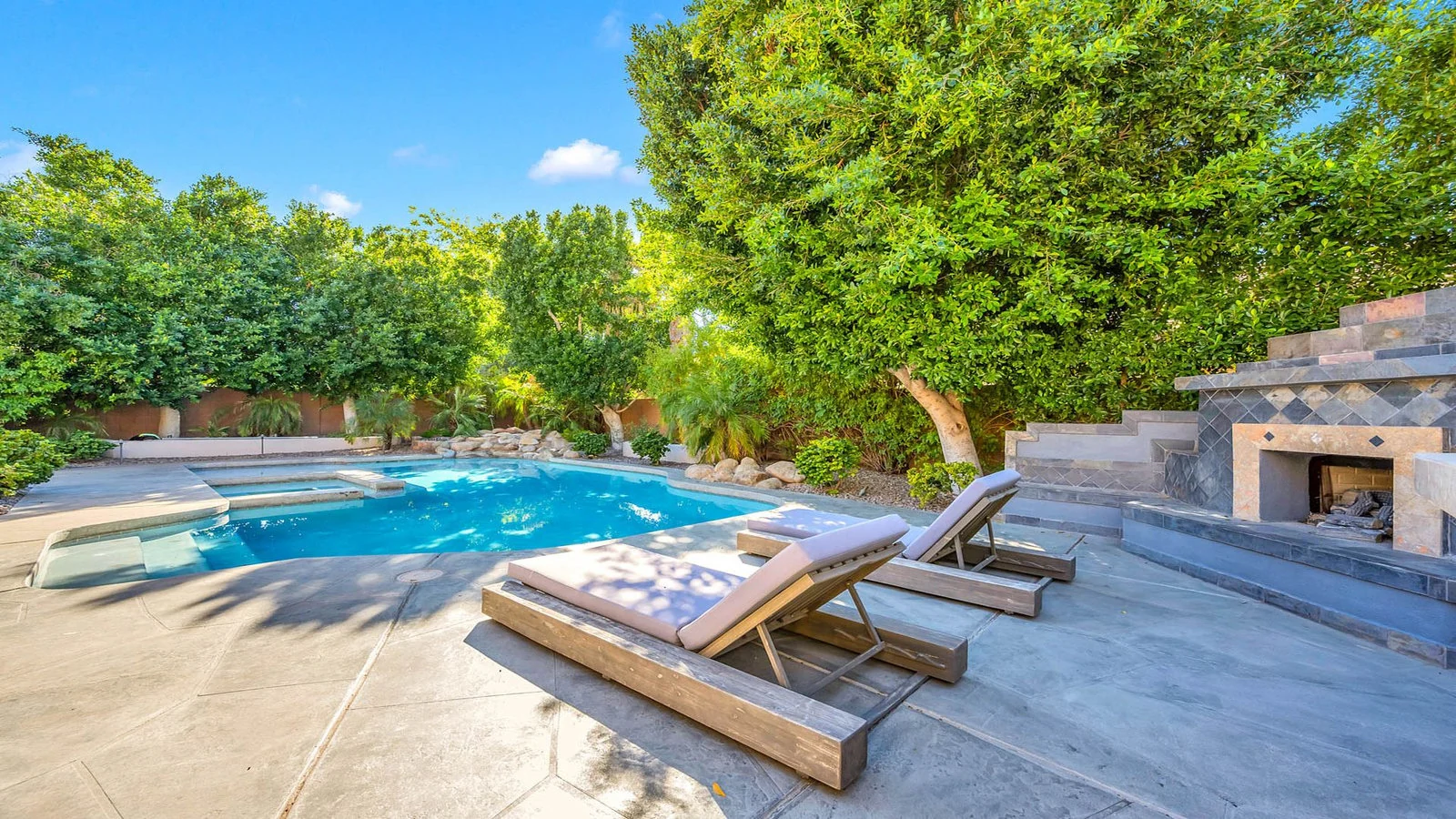 Tempe backyard pool with lounge chairs and fireplace