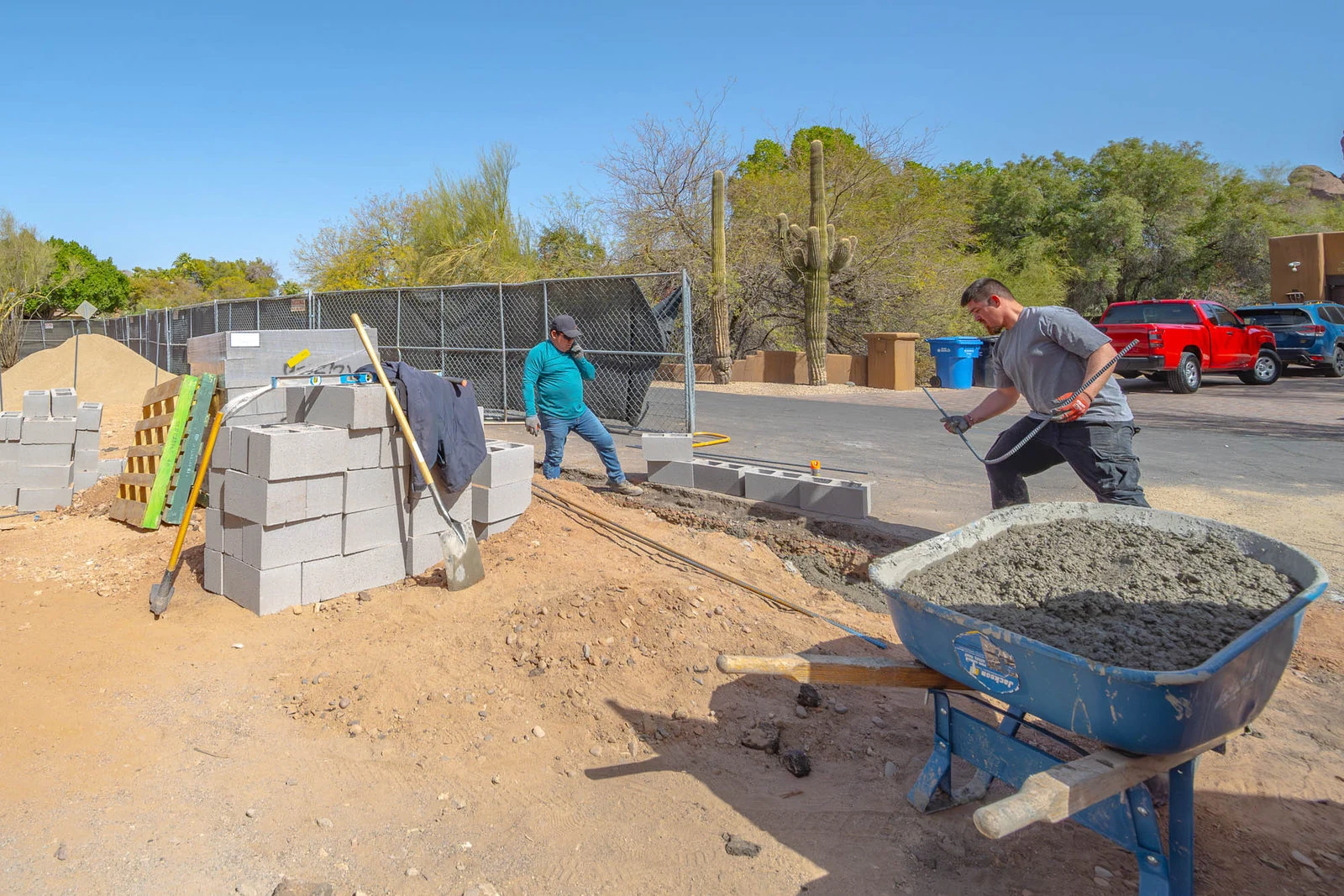 Crew laying concrete block on an active Phoenix job site, progress documentation
