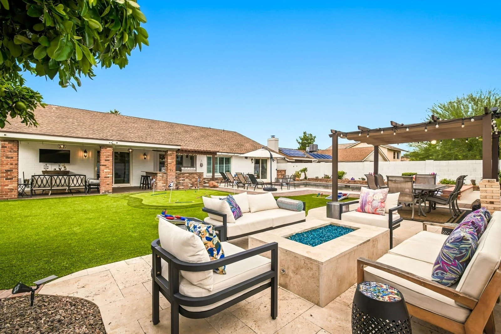 Backyard with fire pit, pergola and putting green photographed in daylight