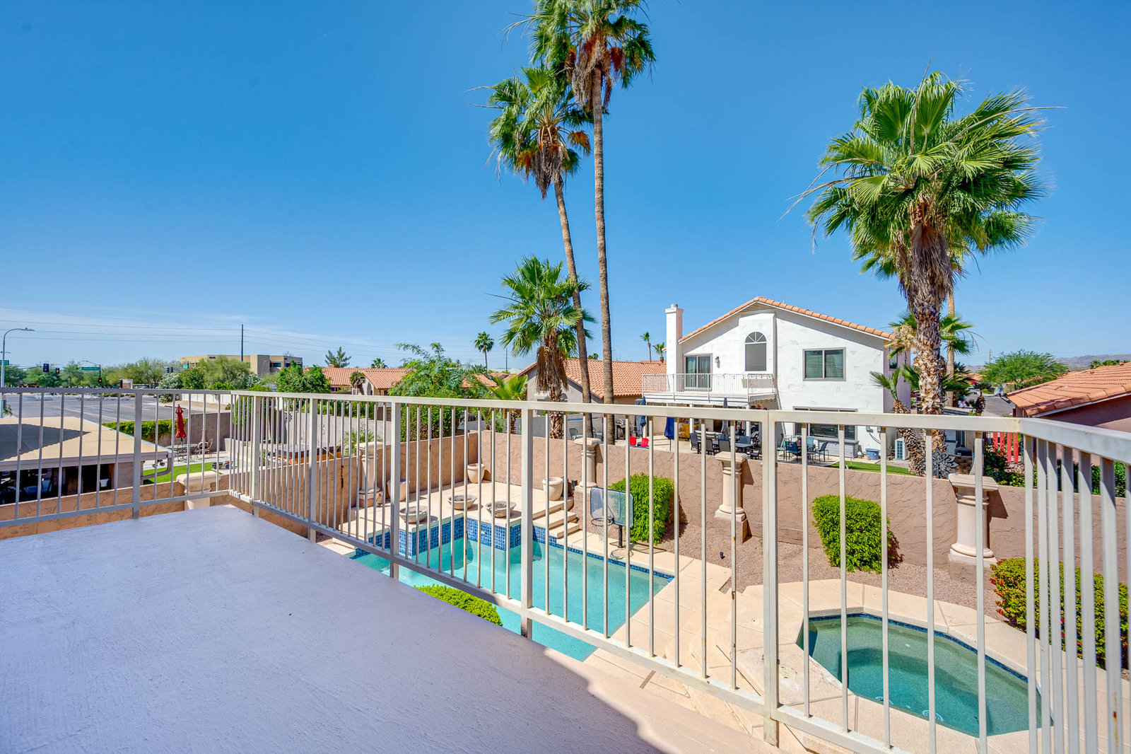 Real estate listing backyard with pool, hot tub, and palm trees