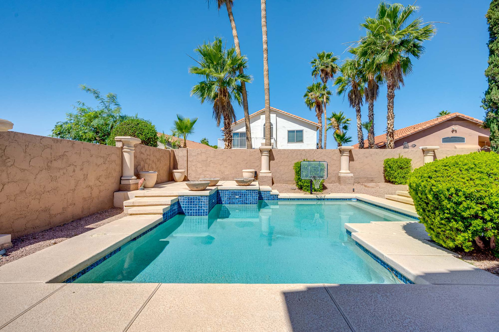 Residential backyard swimming pool with waterfall