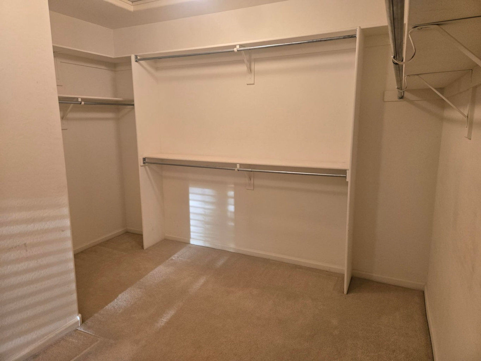 Spacious walk-in closet with shelving and hanging rods